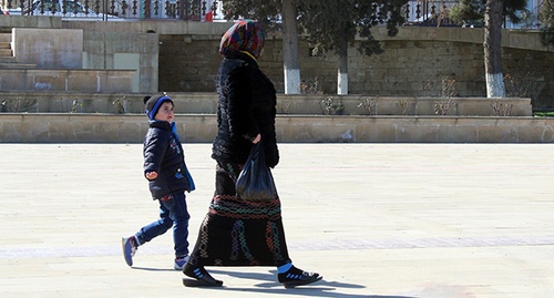 Женщина в платке с ребенком на улице в Дербенте. Март 2015 года. Фото корреспондента "Кавказского узла" Патимат Махмудовой