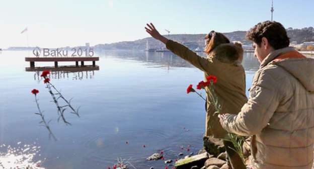 Жители Баку бросают цветы в море в память по погибшим на платформе "Гюнешли". 6 декабря 2015 года. Фото Азиза Каримова для "Кавказского узла"