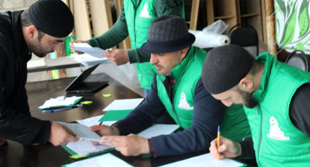 Сотрудники благотворительного фонда "Тешам" и волонтер. Процесс распределения продуктов. Ингушетия, 29 апреля 2016 г. Фото Магомеда Тачиева