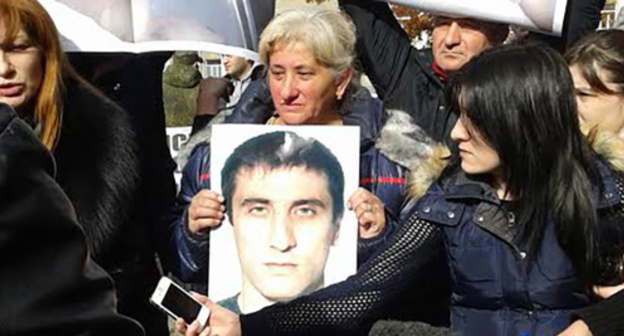 Фото погибшего в руках женщины на митинге возле Дворца правосудия. Фото Александры Кузнецовой для "Кавказского узла"