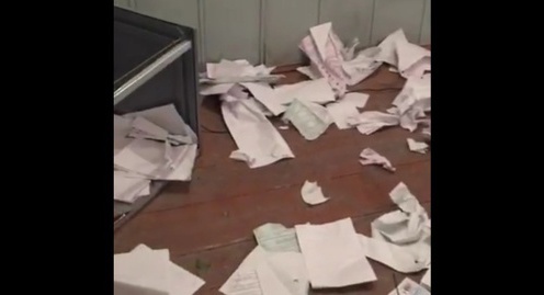 Перевернутая урна для голосования и разбросанные бюллетени на участке в Гоцатле. Скриншот видеозаписи из группы "Дагестан online" в Facebook, facebook.com/groups/dagonline