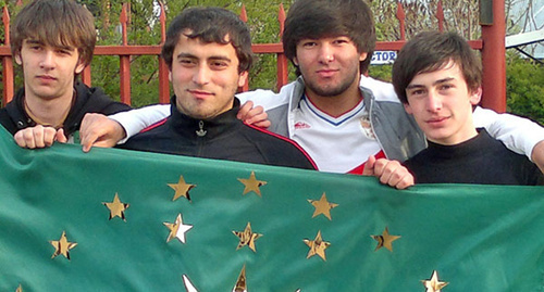 Молодыве люди держат Черкесский флаг. Фото корреспондента "Кавказского узла" Аси Капаевой