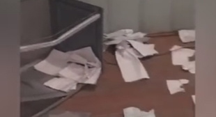 Перевернутая урна для голосования и разбросанные бюллетени на участке в Гоцатле. Скриншот видеозаписи из группы "Дагестан online" в Facebook, facebook.com/groups/dagonline