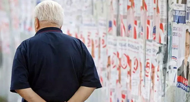 Мужчина прходит мимо предвыборных плакатов. Фото: Sputnik/Alexander Imedashvili