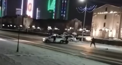 Сотрудник полиции ведет стрельбу по машине в центре Грозного. 17 декабря 2016 года, Грозный. Фото: скриншот видео очевидца, YouTube