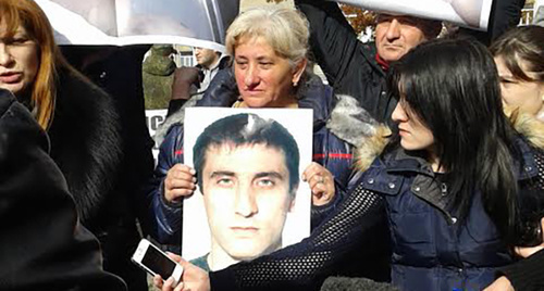 Фото погибшего в руках женщины на митинге возле Дворца правосудия. Фото Эммы Марзоевой для "Кавказского узла"