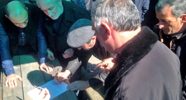 Ветераны подписывают обращение к генеральному прокурору Абхазии Зурабу Ачба. Гумиста, 28 февраля 2017 г. Фото Дмитрия Статейнова для "Кавказского узла"