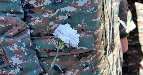 Белая гвоздика в руках военнослужащего. Фото Алвард Григорян для "Кавказского узла"