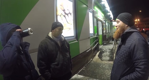 Ислам Исмаилов беседует с двумя мужчинами в ходе "антиалкогольного" рейда в Москве. Фото: скриншот видеозаписи "Стоп Харам. Я готов умереть за ислам!” в YouTube.