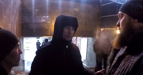 Ислам Исмаилов беседует с двумя мужчинами. Москва. Фото: скриншот видеозаписи "Стоп Харам. Я готов умереть за ислам!” в YouTube.