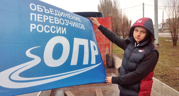 Павел Чипурной демонстрирует флаг ОПР – Объединения перевозчиков России. Фото Вячеслава Ященко для "Кавказского узла"