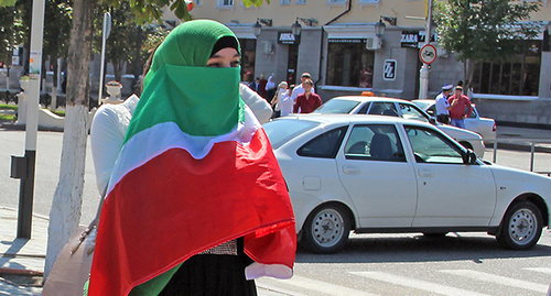 Девушка закрыла лицо чеченским флагом на праздновании дня Республики. Грозный, сентябрь 2014. Фото Магомеда Магомедова для "Кавказского узла"