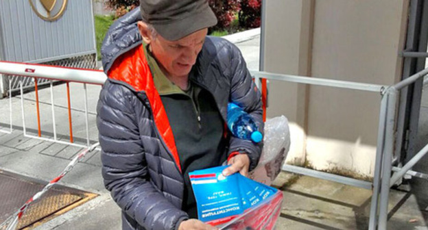 Геннадий Котенко, член движения «Открытый Сочи», передает осужденному на 10 суток Константину Гудимову 12 экземпляров Конституции РФ. Фото Светлана Кравченко для "Кавказского узла"