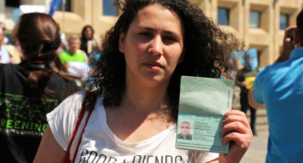 Лейла Мустафаева держит в руках паспорт своего мужа, арестованного журналиста Афгана Мухтарлы. Фото: Георгий Ломсадзе http://russian.eurasianet.org/node/64341