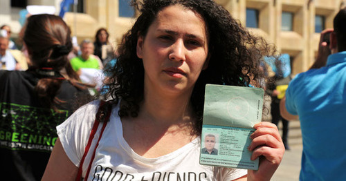 Лейла Мустафаева держит в руках паспорт своего мужа, арестованного журналиста Афгана Мухтарлы. Фото: Георгий Ломсадзе http://russian.eurasianet.org/node/64341