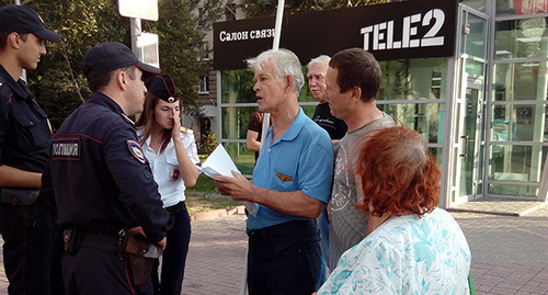 Участник пикета в Волгограде беседует с полицейскими. Фото Татьяны Филимоновой для "Кавказского узла"