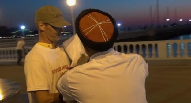 Человек в казачьей форме пытается порвать плакат пикетчика в Геленджике, 16 сентября 2017 года. Фото: Анна Максикова