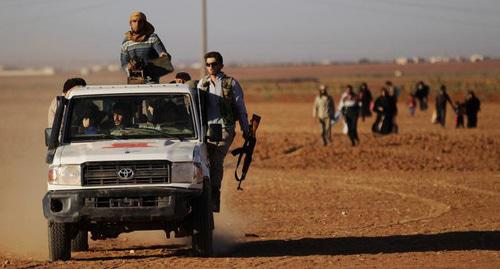 Боевики управляют автомобилем рядом с  беженцами. Фото :
Khalil Ashawi/ REUTERS 