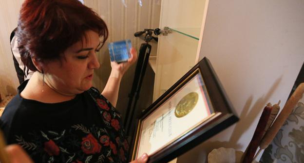 Хадиджа изучает документы о получении Всемирную премию ЮНЕСКО за свободу печати имени Гильермо Кано. Фото Азиза Каримова для "Кавказского узла"