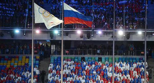 Олимпийский и российский флаги на церемонии закрытия Олимпийских игр 2014. Фото Kremlin.ru
