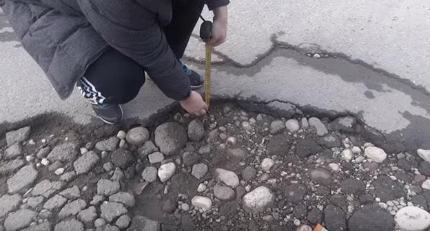 Измерение выбоины на дороге Нальчика. Фото пользователя Олег Доценко https://www.youtube.com/watch?time_continue=233&v=63kPRZSNneg