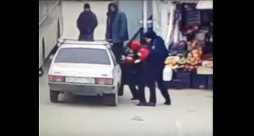 Сотрудник полиции в Дербенте сажает подростка в машину. Фото: кадр видео Нурмагомеда Астарханова https://www.youtube.com/watch?time_continue=34&v=A8kHYg7CJlU