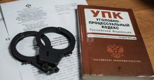 Наручники и Уголовный кодекс. Фото Елены Синеок, "Юга.ру"