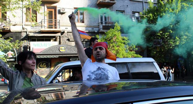 Участник автошествия с файером на проспекте Маштоца. Фото: Тиграна Петросяна для "Кавказского узла"