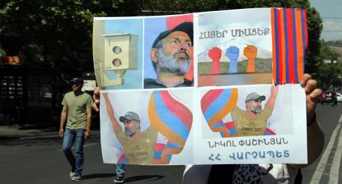 Жительница Еревана демонстрирует плакаты: "Армяне, присоединяйтесь!", "Никол - премьер Армении". Фото Тиграна Петросяна для "Кавказского узла",