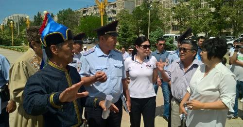 Заместитель начальника полиции по охране общественного порядка УМВД России в Элисте Александр Амтеев (в форме) и представитель администрации Элисты Кермен Бадмаева (справа) требуют от Валерия Бадмаева (в национальном костюме) прекратить съезд. 19 мая 2018 года. Фото Бадмы Бюрчиева для "Кавказского узла"