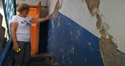 Жилец общежития показывает осыпающуюся штукатурку на стенах. Фото Светланы Кравченко для "Кавказского узла". 