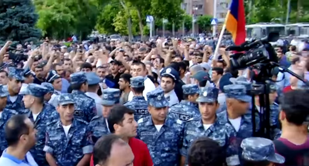Полицейские стоят между сторонниками и противниками мэра Эчмиадзина 16 июня 2018. Кадр видео канала 1in.am LIVE https://www.youtube.com/watch?v=9zDLxMu3Wlg
