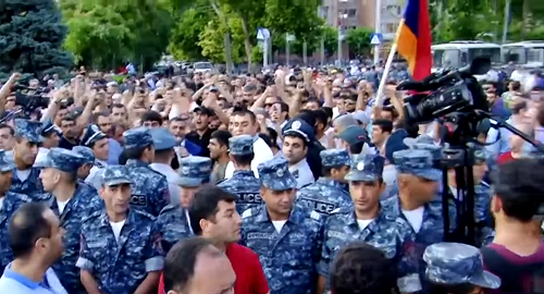 Полицейские стоят между сторонниками и противниками мэра Эчмиадзина 16 июня 2018. Кадр видео канала 1in.am LIVE https://www.youtube.com/watch?v=9zDLxMu3Wlg