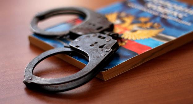 Наручники и Уголовный кодекс. Фото: Валентина Мищенко / Югополис