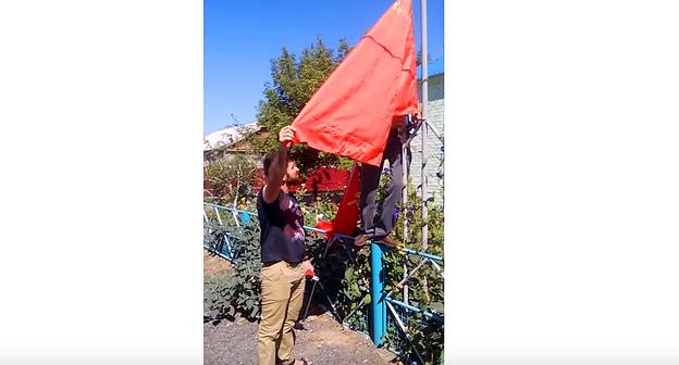 Советский флаг водружается у здания сельсовета. Фото: кадр видео п. Алча РСФСР /СССР "Поднятие флага СССР"
https://www.youtube.com/watch?v=H1u6wnnTZC0