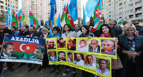 Участники митинга держат в руках плакаты с изображениями политзаключенных. Баку, 25 октября 2015 года. Фото Азиза Каримова для "Кавказского узла"