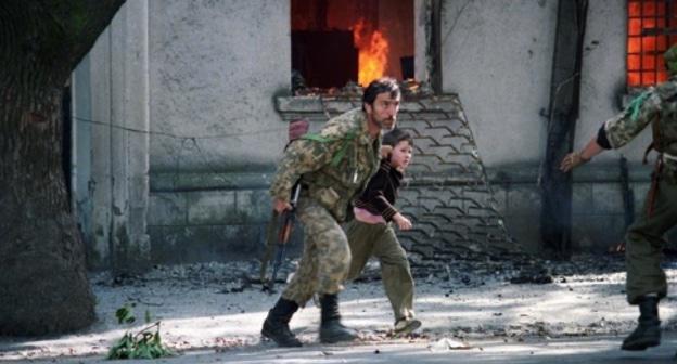 Ополченец выводит ребенка из горящего здания в Сухуми. 1993 год. Фото: Андрей Соловьев, RFE/RL