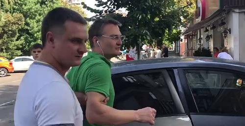 Сотрудники полиции сажают Михаила Беньяша в машину. Кадр из видео Ирины Бархатовой