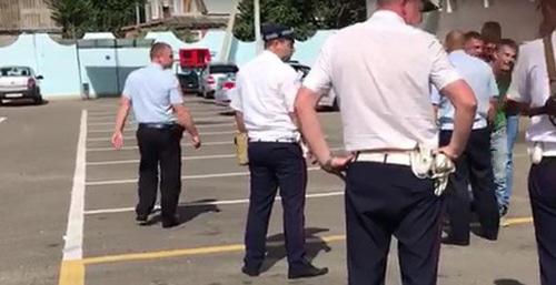 Сотрудники полиции ведут Михаила Беньяша. Кадр из видео Ирины Бархатовой