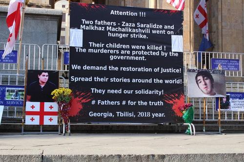Англоязычный плакат у здания парламента в Тбилиси с призывом поддержать требования Саралидзе и Мачаликашвили о справедливом расследовании убийства их сыновей. Фото Инны Кукуджановой для "Кавказского узла".