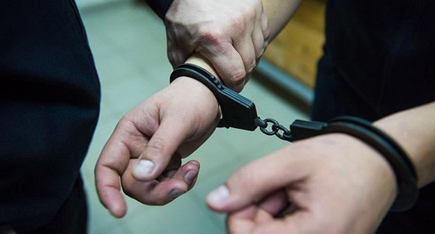Руки в наручниках. Фото Елены Синеок, Юга.ру