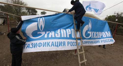 Рабочие устанавливают баннеры. Фото: REUTERS/Eduard Korniyenko