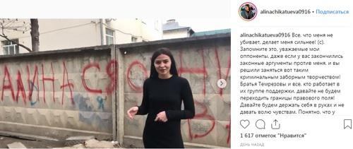Алина Чикатуева на фоне забора с оскорбительной надписью. Фото: скриншот со страницы Алины Чикатуевой в Instagram https://www.instagram.com/p/Bt0zmEZHKQc/