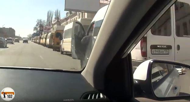 Вид из автомобиля на колонну маршруток в центре Волгограда 20.03.2019. Фото: кадр видео "«Парад ГАЗелей»: в центре Волгограда собрались «на отдых» водители маршруток". 20 марта 2019 года https://youtu.be/QhwTsMM-JKM