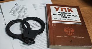 Наручники и уголовный кодекс. Фото Елены Синеок, Юга.ру