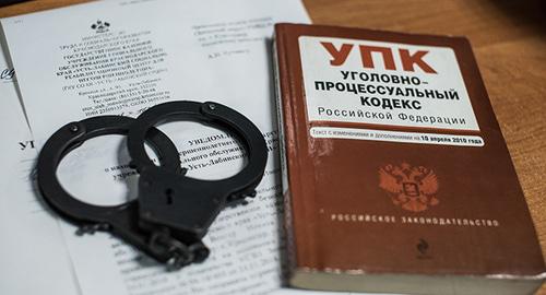 Наручники и уголовный кодекс. Фото Елены Синеок, Юга.ру