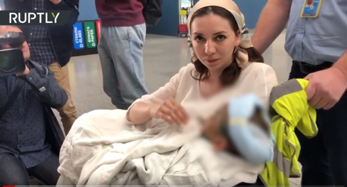 Детский омбудсмен Ингушетии с избитой девочкой на руках. Скриншот видео https://youtu.be/DXrUBspZtd4