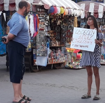 Прохожий интересуется плакатов пикетчицы. Фото Александр Коровайный.