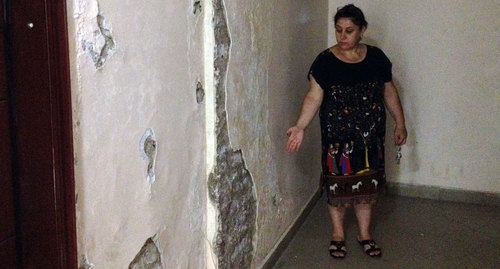 Жительница общежития Наджибат Манафова показывает, что происходит со стенами общежития от сырости. Фото Алены Садовской для "Кавказского узла"