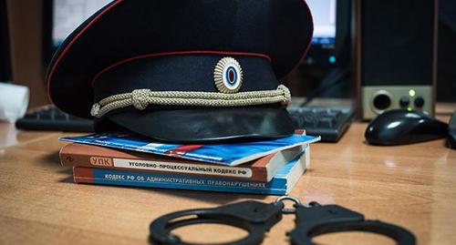 Полицейсккая фуражка и наручники. Фото Елены Синеок, Юга.ру